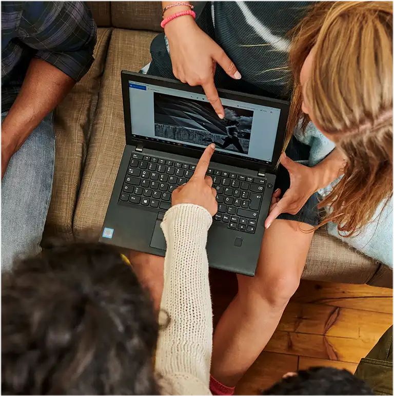Eine Gruppe von Menschen aus der Vogelperspektive mit einem Laptop in ihren Händen (Foto)